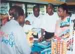 A Cashier in a Mobil Service Station On The Run convenience store explaining the voucher redemption process to Dr Awa Coll-Seck, Executive Director of Roll Back Malaria. http://www.ipieca.org/sites/default/files/system/insecticide.pdf 