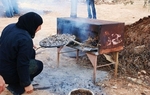 A local Palestinian woman prepares taboun bread for visitors in a traditional wood-burning oven, http://imeu.net/news/article0014939.shtml
